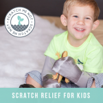 A Gray Solid colored ScratchMeNot on a little boy holding a lizard. With the ScratchMeNot Logo and saying "Scratch Relief For Kids"